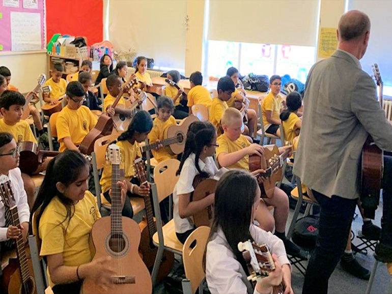 Children learning how to play the guitar